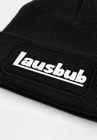 Black ribbed knit beanie featuring a rectangular white logo patch labeled "Lausbub." The material appears soft and stretchable.