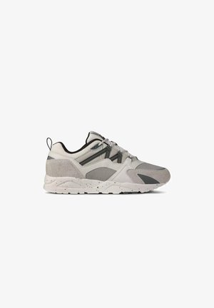 Sneaker grigia e bianca con pannelli in mesh e camoscio, suola sagomata, chiusura con lacci sul davanti e linguetta sul tallone, vista laterale.