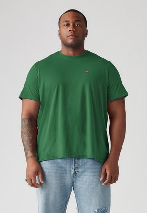 Grønn bomull t-skjorte med korte ermer, med en rund hals og en liten rød Levi's-logo på brystet, kombinert med falmede blå jeans.