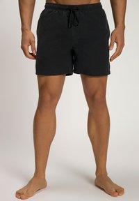 Pantaloni corti neri in cotone con vita elastica e cordoncino; gambe rifinite; senza tasche; texture liscia; lunghezza a metà coscia.