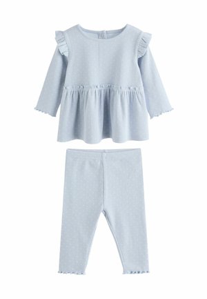 Helles blaues Zweiteiler-Outfit bestehend aus einem langärmeligen Oberteil mit Rüschenschultern und taillierter Passform, kombiniert mit passenden Leggings. Mit Punktenmuster.
