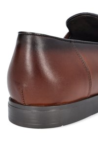 Brązowy skórzany but z gładkim wykończeniem, zaokrąglonym obcasem i czarną gumową podeszwą z teksturowanymi detalami.