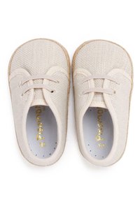Scarpe in tela beige chiaro con punte tonde, lacci elastici e texture intrecciata. Logo dorato all'interno e suola in materiale simile a juta naturale.