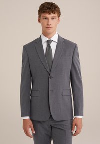 Šedý upravený oblek s výstrihom do špica, uzavretím na jeden gombík, dvoma prednými vreckami a textúrovanou tmavou kravatou. Tkanina má jemný vzor.