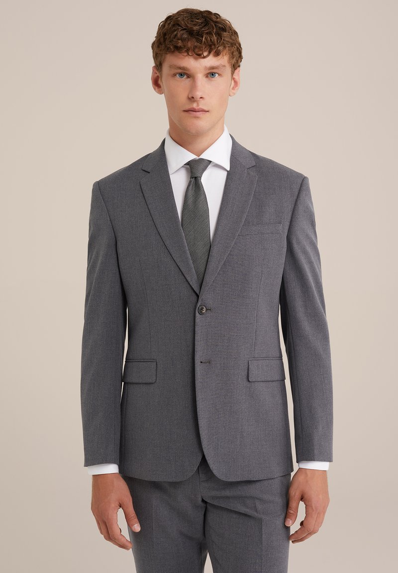 Šedý upravený oblek s výstrihom do špica, uzavretím na jeden gombík, dvoma prednými vreckami a textúrovanou tmavou kravatou. Tkanina má jemný vzor.