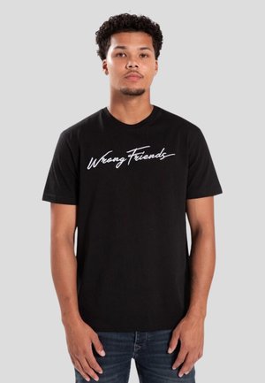 Zwarte katoenen t-shirt met witte opdruk "Wrong Friends" op de borst, korte mouwen en een ronde hals.