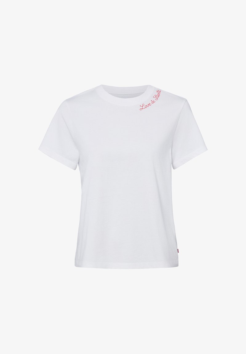 T-shirt blanc à manches courtes avec l'inscription "Love is Love" en texte cursif rouge près du col sur l'épaule gauche.