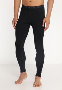 Leggings noirs en matériau léger, avec un design ajusté, une taille élastique avec le logo "ICEBREAKER" et une texture lisse.