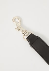 Czarny skórzany pasek o gładkiej teksturze, z metalowym klipsem i pierścieniem w kolorze srebrnym do mocowania.