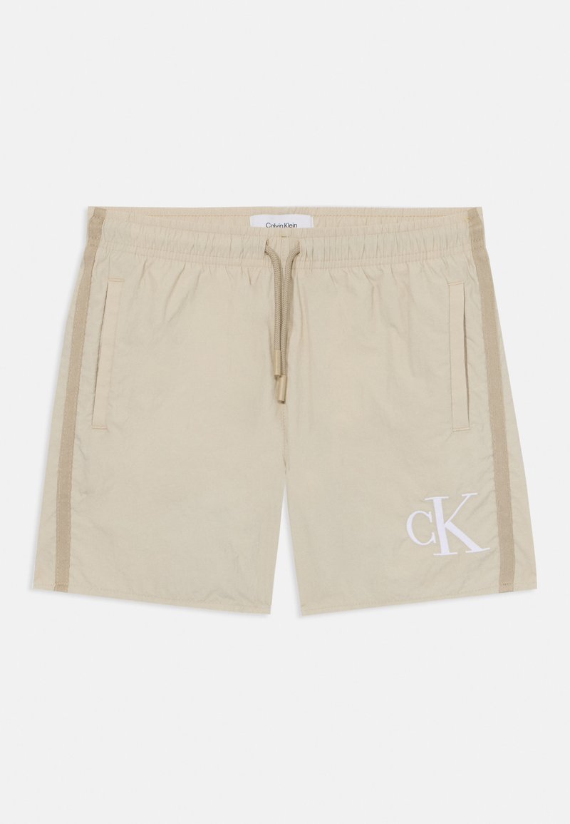 Calções bege feitos de um tecido leve, com uma cintura elástica, detalhe de cordão, bolsos laterais e um discreto logótipo CK em branco.