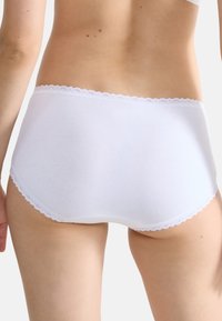 Culotte hipster blanche en coton avec une finition en dentelle douce le long de la taille et des ouvertures des jambes, avec un design lisse et sans coutures.