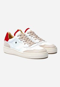 Zapatillas deportivas blancas de corte bajo con acentos de ante beige, cordones beige, logo negro "X" en el costado y detalles rojos en el tal�ón y la lengüeta.