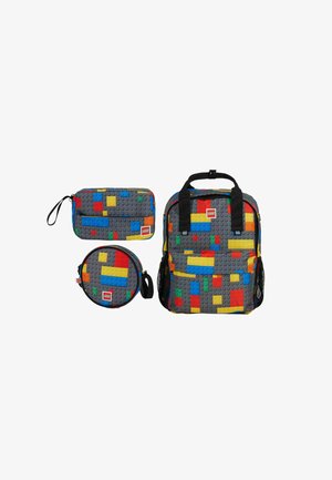 Trois sacs gris avec des motifs colorés de briques LEGO, comprenant un sac à dos, une pochette rectangulaire et un étui rond, tous avec des logos LEGO.