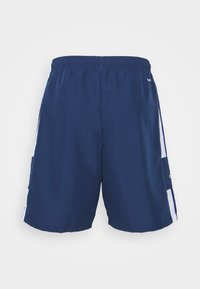Námořnické modré sportovní šortky s texturovanou tkaninou, elastickým pasem a kontrastními bílými bočními panely. Na boku je logo.
