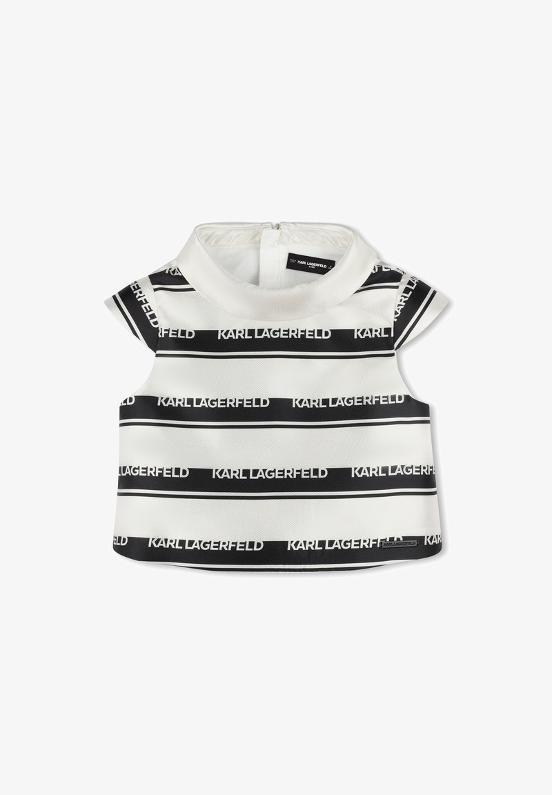 Top sans manches blanc et noir avec un col haut, présentant le texte répété "KARL LAGERFELD" en gras. Tissu lisse, légèrement texturé.