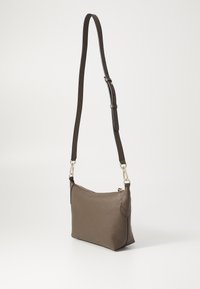 Borsa a spalla in pelle marrone con finitura testurizzata, una lunga tracolla regolabile e accessori in tonalità oro. Apertura con zip sulla parte superiore.
