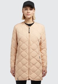 Abrigo largo acolchado de suave tela en tono rosa empolvado, con cuello redondeado, cremallera frontal y un sutil patrón geométrico en toda la prenda.