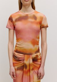 Kurzarmoberteil mit einem Verlauf von Orange und Pink sowie abstrakten, wirbelnden Mustern. Glatte Textur und figurbetontes Design mit runden Ausschnitt.