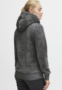 Grijze fleece hoodie met een zachte, gestructureerde oppervlak, ribbelmanchetten en een ribbelzoom. Ontworpen voor warmte en comfort.