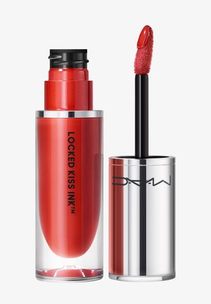 Rossetto liquido rosso in un contenitore cilindrico trasparente. Presenta un applicatore nero con una punta morbida e testurizzata. Dettagli argentati sul tappo.