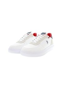 Valkoiset sneakerit, joissa on nahka- ja samettipaneelit, joissa on rei'itetty varvas, harmaat yksityiskohdat, punainen kantapää ja logo yksityiskohtana sivussa.