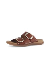 Brown leather slide sandal with two large silver buckles, smooth footbed, and tan rubber outsole; features decorative stitching.