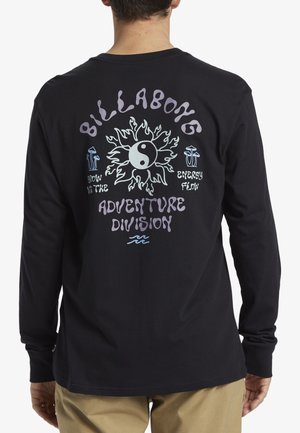 Langärmliges schwarzes T-Shirt mit einem bunten Grafikdesign auf der Rückseite, das eine Sonne, ein Yin-Yang-Symbol und Text in verschiedenen Schriftarten zeigt.
