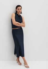 Marineblaues Zweiteiler-Outfit mit einem ärmellosen Top mit Schalkragen und einem passenden Midirock mit seitlichem Schlitz, aus glattem Stoff gefertigt.