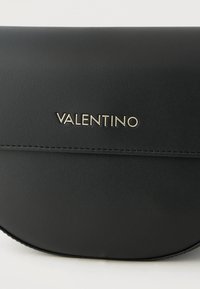 Μαύρο δερμάτινο τσαντάκι Valentino με λεία υφή και εμφανείς ραφές κατά μήκος της άκρης της μπροστινής πτυχής.