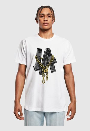 Hvid bomulds T-shirt med et grafisk design af "LA" i sort med en gylden kæde og låsdetalje, sat mod en ensfarvet baggrund.