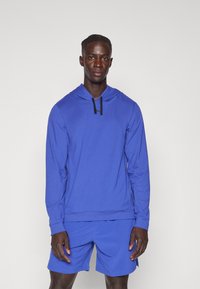 Blauwe hoodie met lange mouwen en een zwarte trekkoord, gecombineerd met blauwe shorts. Gladde textuur, sportieve pasvorm en naadloze ontwerpelementen.