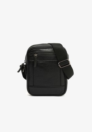 Black textured leather crossbody bag with front zip pocket and adjustable wide fabric shoulder strap.
