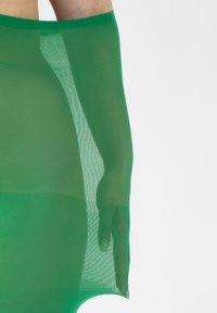 Falda de tela transparente verde con una textura suave; cuenta con una cinturilla elástica y un diseño ajustado que muestra una mano a un lado.
