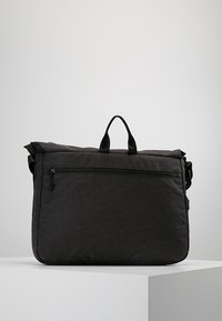 Borsa a spalla in tessuto nero con manico superiore, tracolla regolabile e tasca con zip frontale. Forma rettangolare, materiale testurizzato e design strutturato.