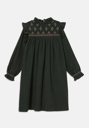 Robe vert foncé à manches longues, corsage froncé avec des coutures décoratives, encolure froncée et poignets à volants. Coupe décontractée ample.