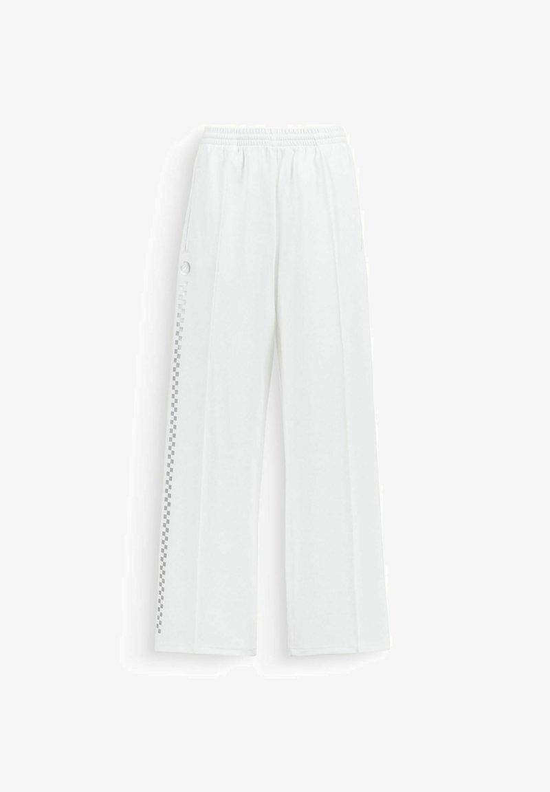 Pantalon blanc à jambes larges avec taille élastique, présentant une rayure à carreaux verticale et des boutons-pression le long de la couture latérale extérieure.
