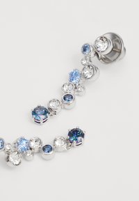 Silberfarbener Ohrcuff, der mit verschiedenen runden und ovalen blauen und klaren Kristallen verziert ist und unterschiedliche Größen und Fassungen aufweist, um einen strukturierten Look zu erzeugen.