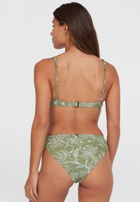 Set di bikini verde con motivo floreale, spalline regolabili e chiusura a clip. Il tessuto ha una superficie liscia con un fondo a vita bassa.