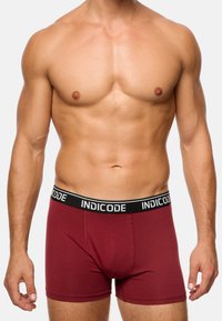 Boxeri burgundy cu un elastic negru la talie, având inscripționat "INDICODE" în litere albe. Material moale cu o potrivire strânsă.