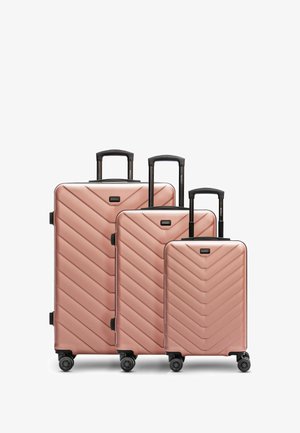 Set di tre valigie rigide in oro rosato con motivo a zigzag, manici retrattili e quattro ruote girevoli per una facile mobilità.