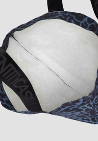 Torba na ramię w czarno-niebieski wzór w panterę z szerokimi materiałowymi paskami. Wnętrze wyłożone białym materiałem, o niestrukturalnym, miękkim kształcie.