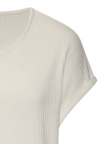 Heledbeez värvi struktureeritud topp, mis on valmistatud soonikmaterjalist. Omab ümmargust kaelaauk ja lühikesi rullitud varrukaid.