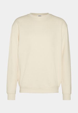 Kreemivärvi dressipluus pehmest kangast, millel on soonikkoes ümar kaelus, langenud õlad ja soonikkoes varrukate äärted. Lihtne, kaunistusteta disain.