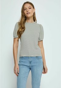 Striped short-sleeve top in black and white, featuring a fitted design with a high neckline and puffed sleeves. Worn with blue denim jeans.