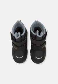 Bottes noires pour enfant avec un upper en tissu et une doublure grise douce. Sangles Velcro réglables et semelles texturées pour l'adhérence. Design à bout rond.