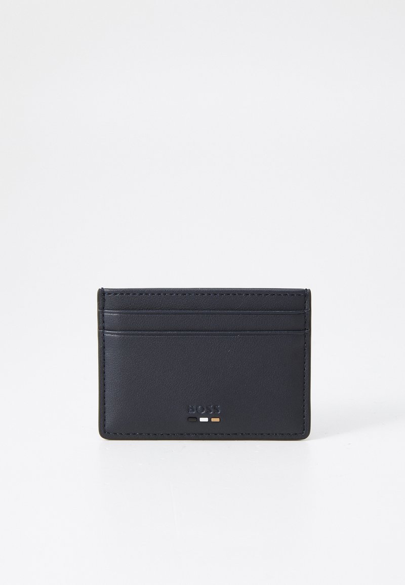 Navy leather cardholder with four card slots, embossed logo, and subtle stitch detailing. Smooth texture and slim profile for easy storage.