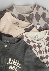 Set aus vier gerippten Babybodys in Beige, Grau und gemusterten Stoffen. Mit Knöpfen und einem grafischen Text auf einem Bodysuit; weicher Stoff.