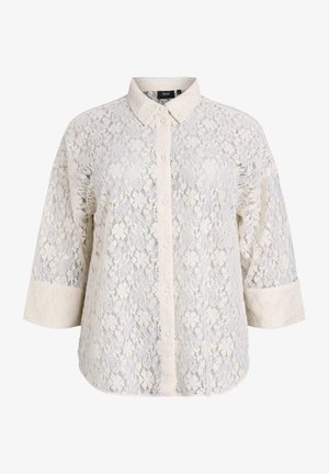 Blusa in pizzo color crema con fronte a bottoni, colletto e maniche a tre quarti. Presenta intricate fantasie floreali e un tessuto testurizzato.