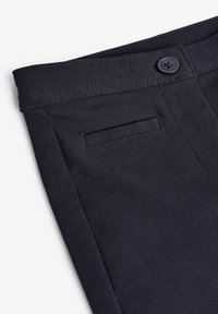 Pantaloni blu navy con una texture liscia, caratterizzati da una chiusura a singolo bottone, una vita piatta e una tasca posteriore con bordo cucito.