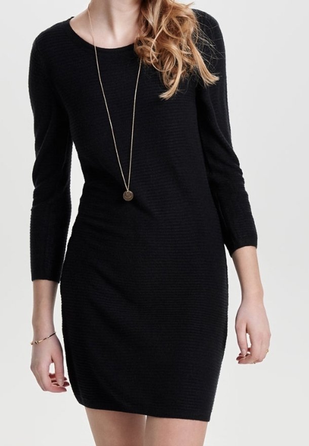 Robe en tricot noire à manches trois-quarts, silhouette ajustée, col rond et texture subtile. Collier en or simple en accent.